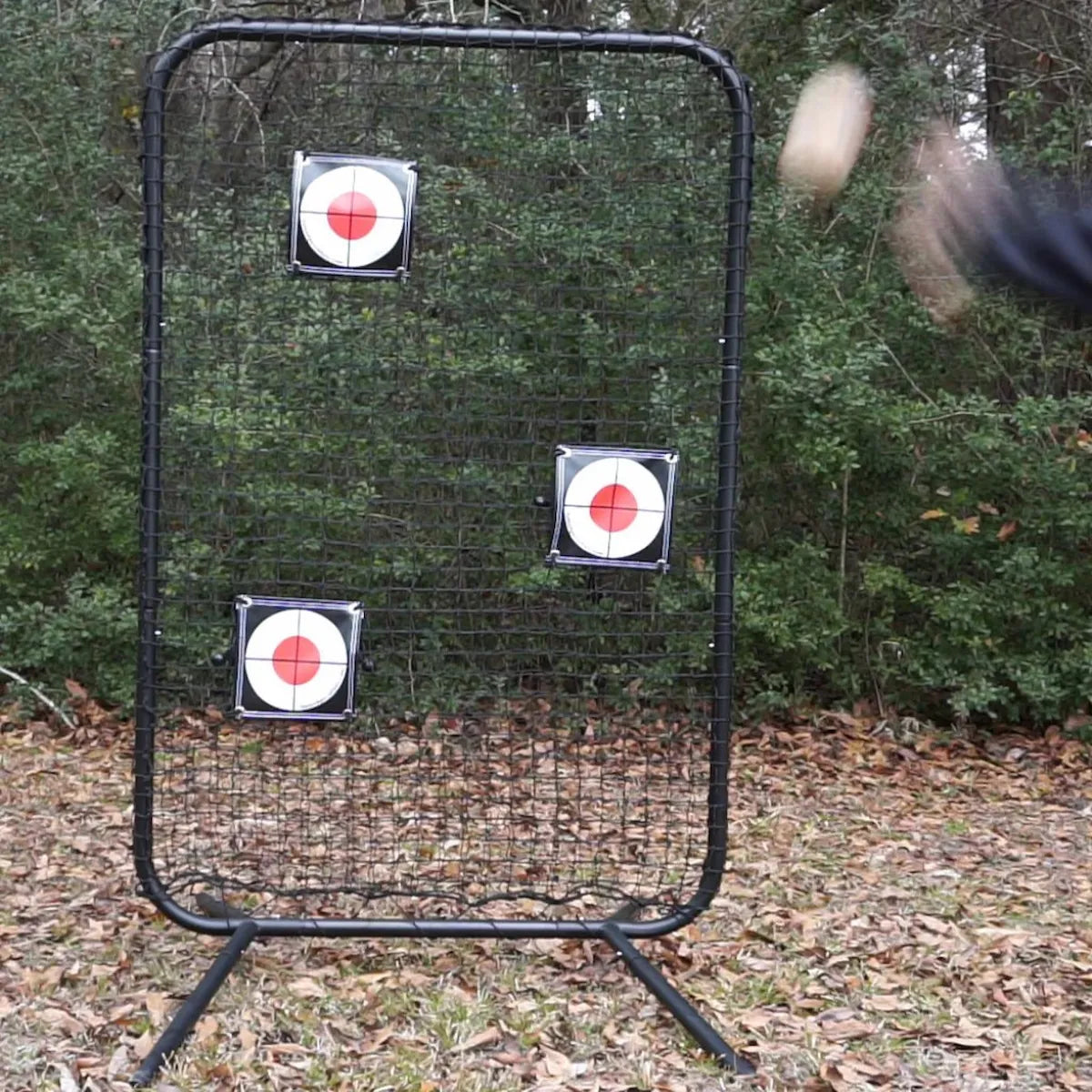 Baseball player throwing at TAP® Precision Target mounted on training net during practice session