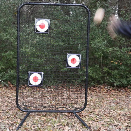 Baseball player throwing at TAP® Precision Target mounted on training net during practice session