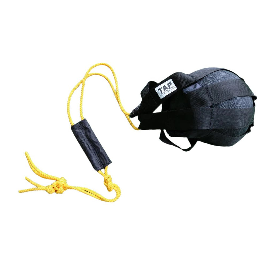 Product photo of TAP® Hammer Net: A durable black training net with yellow ropes and a handle. A four-pound medicine ball is securely held within the net, demonstrating its use for dynamic training exercises such as slams, swings, and chops.