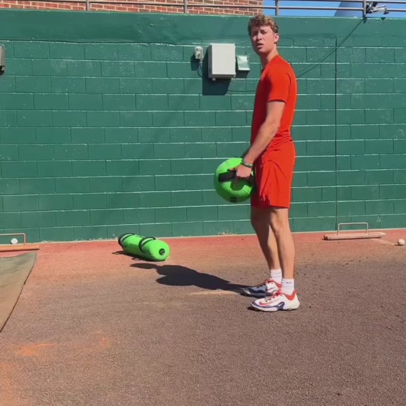 Athlete warm-up using the KHAOS Water Ball baseball training tool, creating unstable water resistance to prepare the throwing shoulder, scapular stabilizers, and core for pitching and overhead throwing.