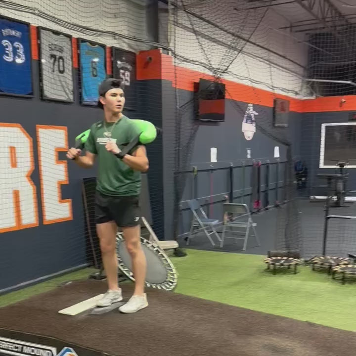 Athlete performing a pitching delivery with the KHAOS Bulgarian Water Bag, utilizing dynamic water perturbations to drive kinetic chain stabilization and maximize power transfer through the throwing arm.