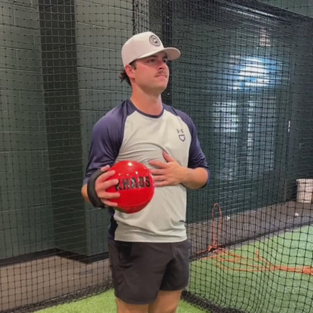 Collegiate pitchers performing pre-throwing warm-up drills with the Khaos® Shoulder Shaker to support blood flow and dynamic shoulder stability prior to pitching.