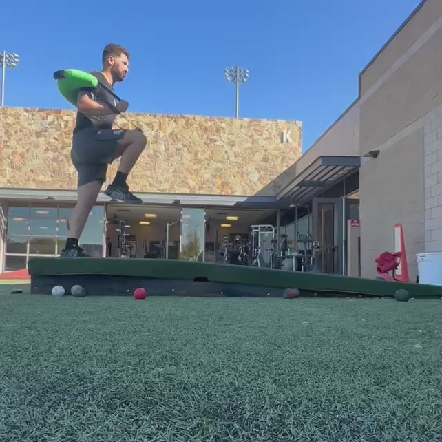 Athlete utilizing the KHAOS Bulgarian Water Bag to train a stable front foot landing, using dynamic water perturbations to drive lead-leg stabilization and power transfer through the throwing chain.