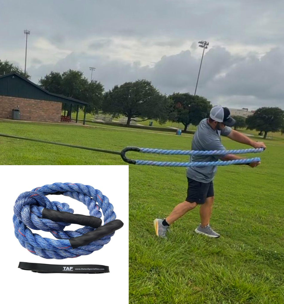 Action shot of a baseball player engaged in a rotational swinging drill using the Oates Specialties Dynamic Rope System. The athlete is pulling the short heavy rope against the anchored flat band, demonstrating a focus on developing core power and stability through accommodating resistance.