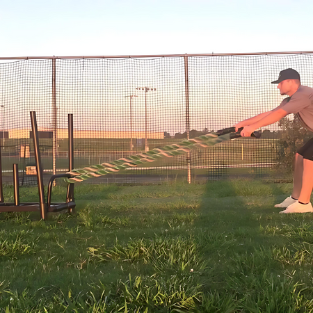 Athlete performing a strength and endurance workout by pulling the KHAOS® Wheelbarrow Sled without a wheel, using a 2-inch heavy rope on a training surface for resistance-based conditioning.