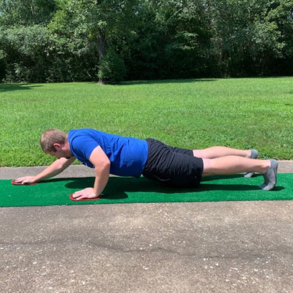 Fitness gliders for home workouts: Athlete sliding hands on hard floor using TAP Gliders for advanced upper body and core strength.