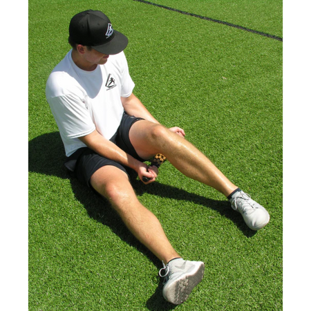 An athlete uses the relief stick for a myofascial release of the hamstring muscle. 