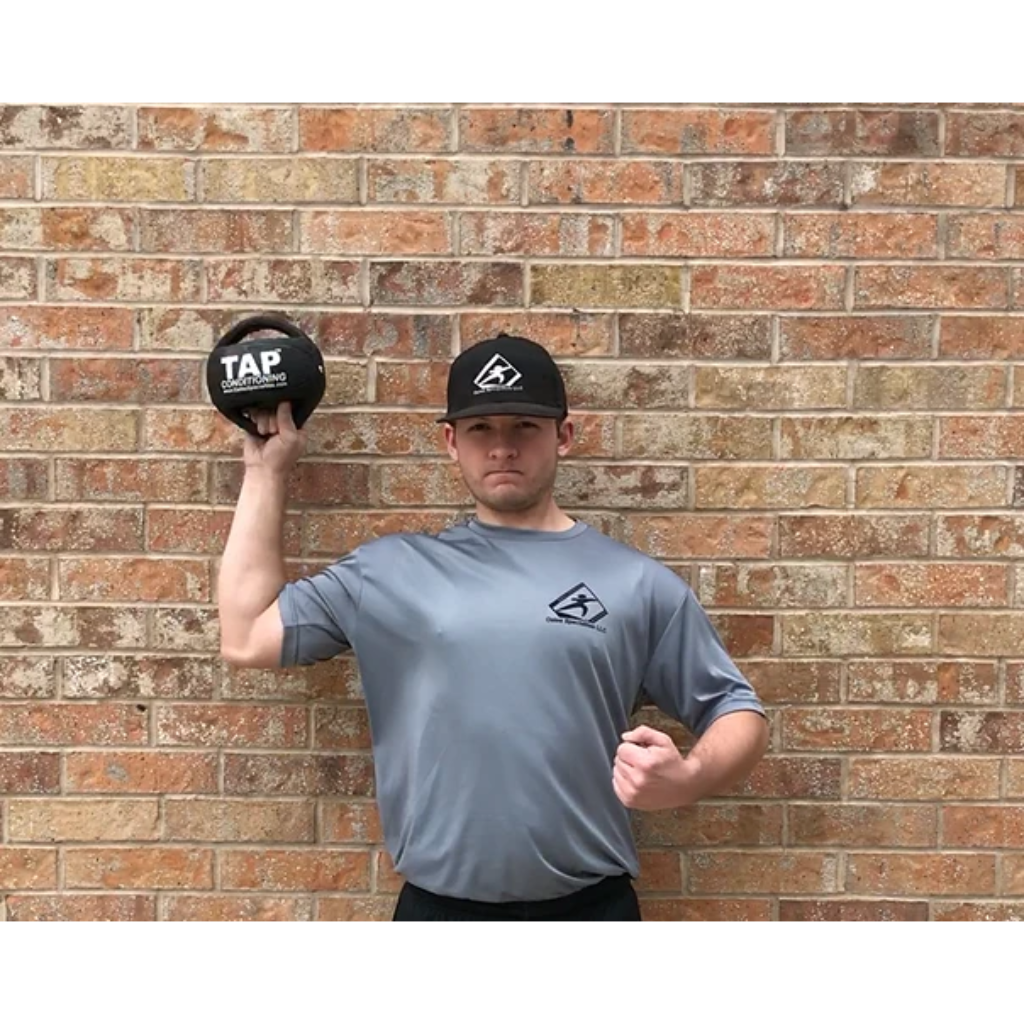 Athlete training with a Double Handle Medicine Ball—focusing on shoulder strength and enhancing internal rotation through controlled movement patterns.