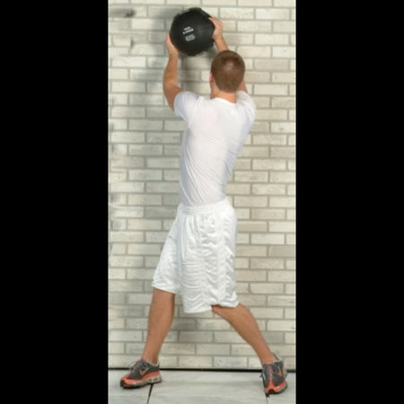 Athlete executing overhead side chops with a Double Handle Medicine Ball against a wall—developing rotational power, shoulder endurance, and core stability.