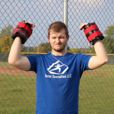 An athlete performing overhead shoulder exercise with weighted cuffs for added resistance.