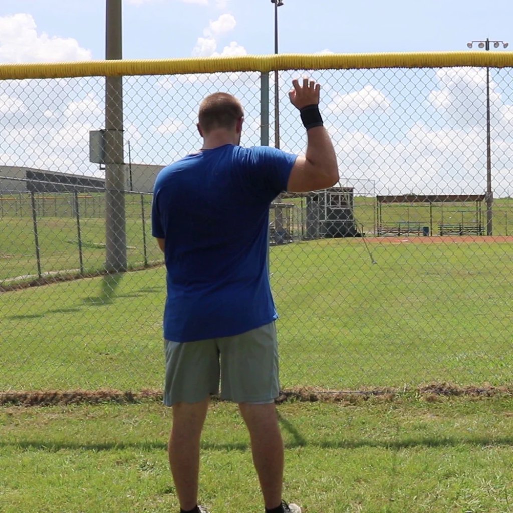 An athlete placing tension on the shoulder to improve joint stability and rotator cuff health using the Pitcher's Friend Tubing.