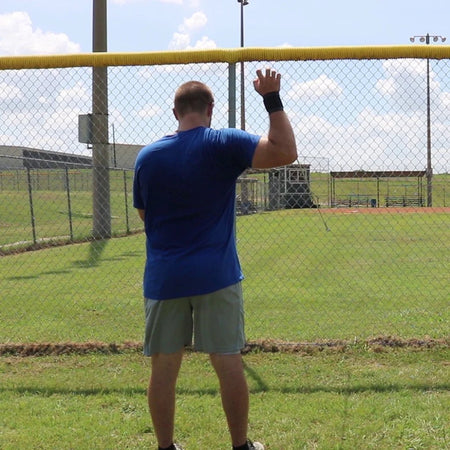 An athlete placing tension on the shoulder to improve joint stability and rotator cuff health using the Pitcher's Friend Tubing.