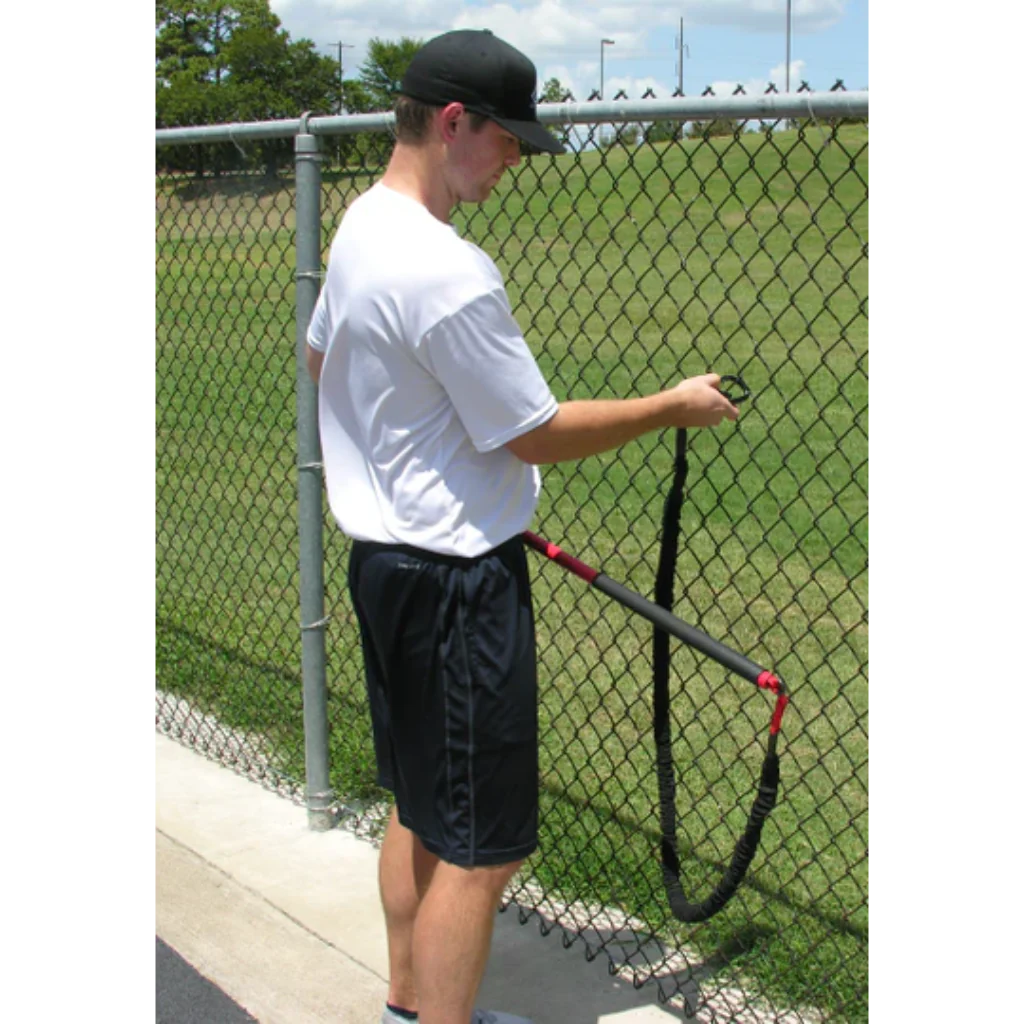 Athlete securing the Pivoter Bar Bungee to a fence, preparing for dynamic resistance training to enhance strength and stability.