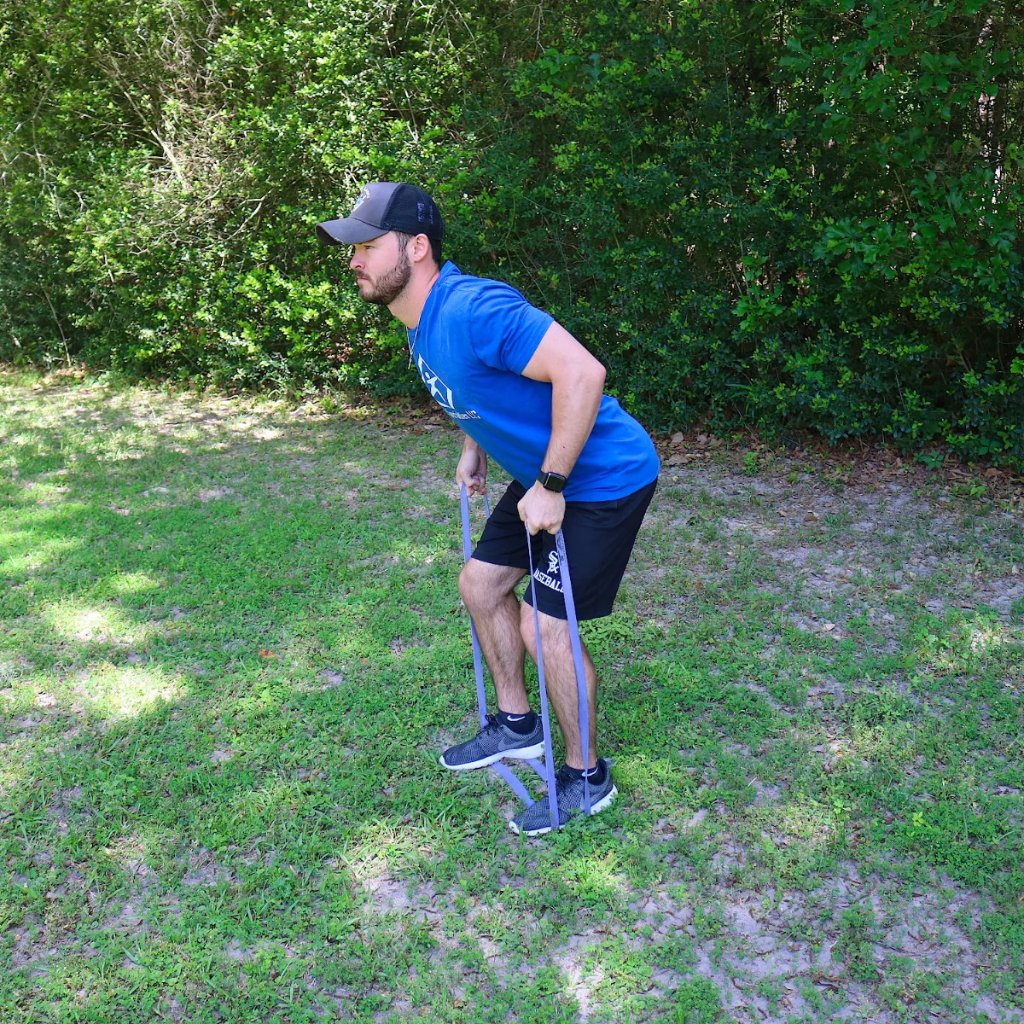 Bent-over row exercise using Purple Giant Flat Band for shoulder and triceps strength training.