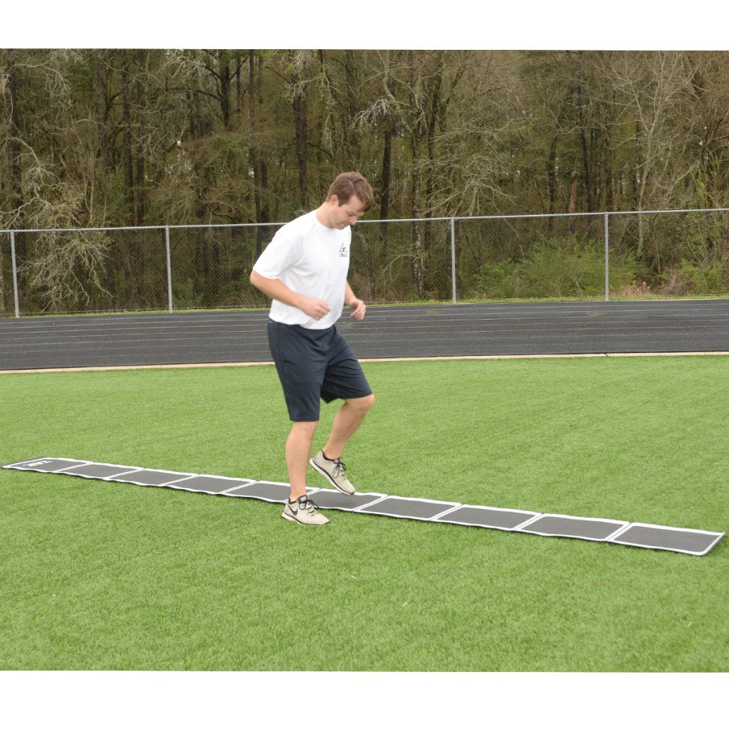 Athlete using the tangle-free roll out speed ladder on a turf surface to perform agility and quick feet drills.
