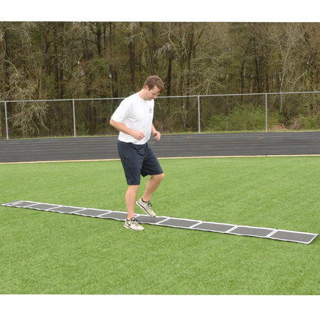 Athlete using the tangle-free roll out speed ladder on a turf surface to perform agility and quick feet drills.