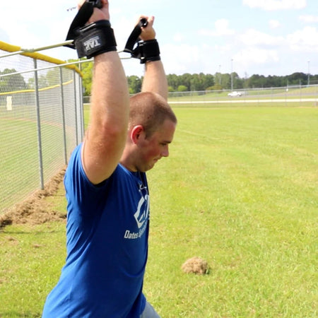 Athlete executing a full-body chop with Silver Ultimate Pitcher's Friend Tubing to enhance core power and strength.