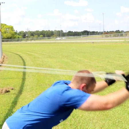 Athlete executing a full-body chop with Silver Ultimate Pitcher's Friend Tubing to enhance core power and strength.