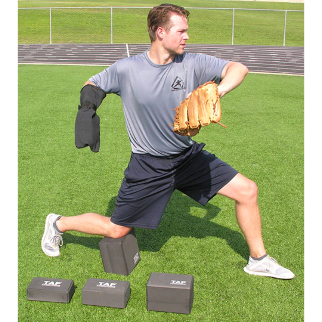 Baseball pitcher performing a half-kneeling drill with the TAP® Kneeling Block and a Baseball Training Sock.